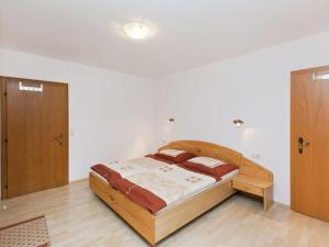 ein Schlafzimmer mit einem Holzbett in einem Zimmer in der Unterkunft Lush Apartment in Hollersbach im Pinzgau with Terrace in Hollersbach im Pinzgau