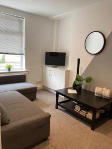 a living room with a couch and a table with a mirror at Buller View in York