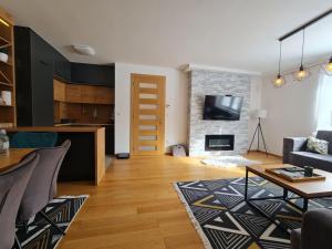 a living room with a table and a fireplace at Apartment 55 in Bjelašnica