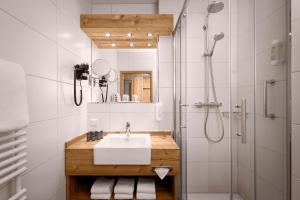 a bathroom with a sink, toilet and bathtub at Hyperion Hotel Garmisch – Partenkirchen in Garmisch-Partenkirchen