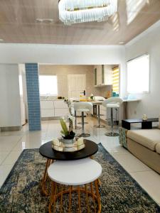 a living room and kitchen with a table and chairs at Monaco villa Gaborone in Gaborone