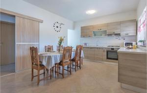 a kitchen with a table and chairs in a room at Amazing Home In Marcana With House A Panoramic View in Divšići