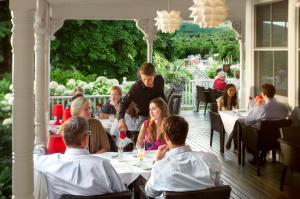 eine Gruppe von Menschen, die an einem Tisch in einem Restaurant sitzen in der Unterkunft Relais Chateaux Camden Harbour Inn in Camden