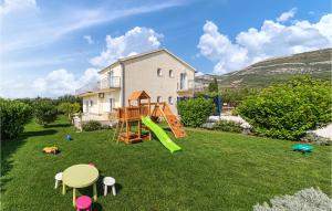einen Hof mit einem Spielplatz und einem Haus in der Unterkunft Lovely Home In Kastel Stari With House Sea View in Kaštela