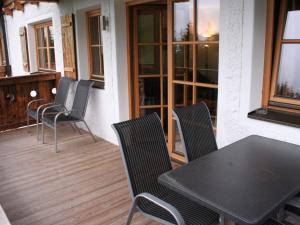 a patio with a table and chairs on a deck at Apartment with Sauna near Ski Slopes in Mittersill in Hollersbach im Pinzgau