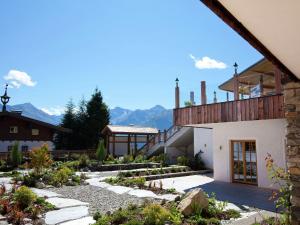 a house with a garden and mountains in the background at Apartment with a lift in Mittersill Salzburg in Hollersbach im Pinzgau