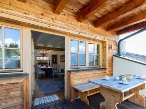 een houten hut met een tafel en ramen bij Apartment with a lift in Mittersill Salzburg in Hollersbach im Pinzgau
