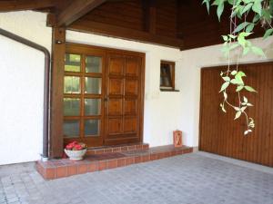 a house with a wooden door and a pot of flowers at Spacious Villa near Lake in Goldegg in Goldegg
