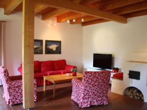 ゴールデックにあるSpacious Villa near Lake in Goldeggのリビングルーム(赤いソファ、椅子付)