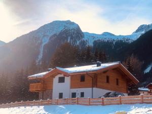 a house in the snow with a mountain in the background at Premium Chalet in Krimml with sauna in Krimml