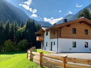 a house with a wooden fence next to a field at Premium Chalet in Krimml with sauna in Krimml