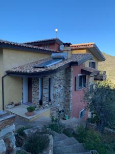 a stone house with a roof on a hill at Il Vecchio Ulivo Sa Tanca in Ussàssai