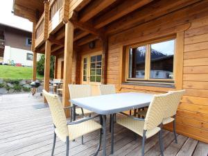 a table and chairs on a wooden deck at Comfortable Chalet with Whirlpool and Sauna in Krimml in Krimml