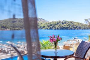 a table with a vase of flowers sitting on top of a balcony at Blue Green Bay in Panormos Skopelos