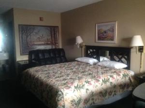 a hotel room with a bed and a chair at HighWay Inn in Mocksville