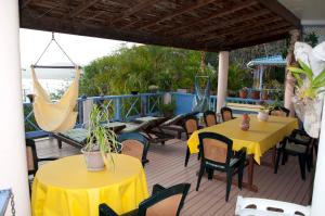 a patio with yellow tables and chairs on a deck at Villa Caribbean Dream in Vieux Fort