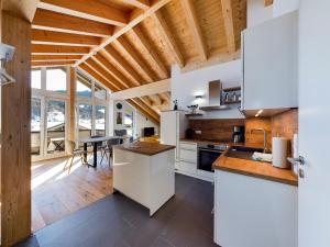 eine Küche mit weißen Geräten und ein Esszimmer in der Unterkunft Herzstück in Garmisch-Partenkirchen