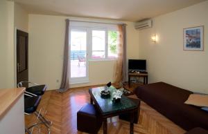 a living room with a couch and a table at Apartments Beautiful Sandy Beach in Split