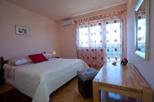 a bedroom with a bed and a table and window at Apartments Beautiful Sandy Beach in Split