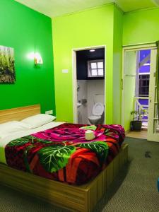 ein grünes Schlafzimmer mit einem Bett in einem Zimmer in der Unterkunft Rose Haven Hotel in Cameron Highlands