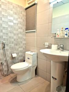 La salle de bains est pourvue de toilettes et d'un lavabo. dans l'établissement Tranquil & Delightful 1 Bed Apt In Bahria Town, à Rawalpindi