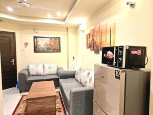 sala de estar con sofá y TV en la nevera en Tranquil & Delightful 1 Bed Apt In Bahria Town en Rawalpindi