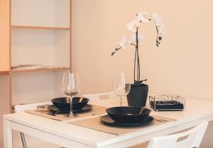 uma mesa de jantar com dois copos e uma flor em Ring Stop Holiday Apartment em Sigulda