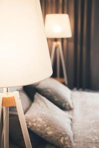 a bedroom with a lamp and pillows on a bed at Ring Stop Holiday Apartment in Sigulda