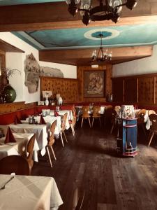 um restaurante com mesas e cadeiras num quarto em Villa Residence Franziskus em Tirolo