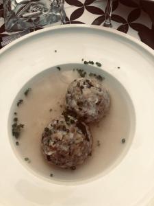 deux boulettes de viande dans un bol blanc sur une assiette dans l'établissement Villa Residence Franziskus, à Tirolo