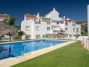 un gran edificio blanco con una piscina frente a él en 2060-Newly furnished 2 bedrooms apt with golf, en Estepona