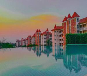 une grande piscine d'eau devant certains bâtiments dans l'établissement Happy City Golf & Resort, à Chiang Rai