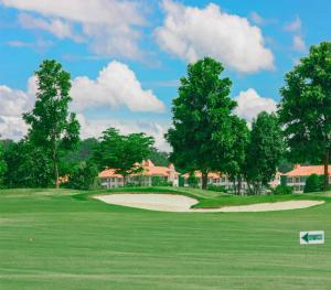 vista su un campo da golf con case sullo sfondo di Happy City Golf & Resort a Chiang Rai