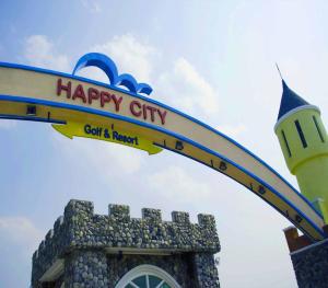 un cartello con scritto "campo da golf cittadino felice" e "resort" in cima a un edificio di Happy City Golf & Resort a Chiang Rai