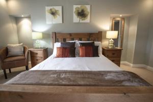 a bedroom with a large bed and a chair at Hill Top Farm 8 in Bainbridge