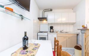 a kitchen with a table with a bottle of wine at Amazing Apartment In Bakar With Kitchen in Bakar