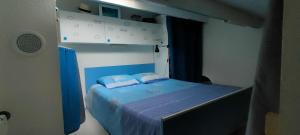 1 dormitorio con 1 cama azul y 2 almohadas en Studio avec terrasse à 300m de la plage, en Fleury