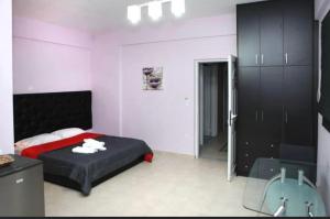 - une chambre avec un lit et une armoire noire dans l'établissement Spilios Apartment, à Nauplie