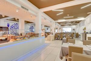 un restaurant avec des tables et des chaises et un buffet dans l'établissement Hotel Nettuno, à Lido di Jesolo