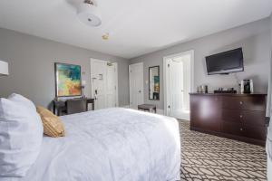 a bedroom with a white bed and a flat screen tv at The Idlewyld Inn and Spa in London