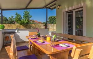 a wooden table and chairs on a patio at Amazing Home In Fazana With Kitchen in Fažana