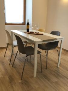 un tavolo bianco con due bicchieri e sedie da vino di Appartamenti Piccolo Borgo ad Arco