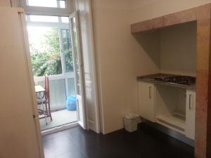 a kitchen with a door leading to a balcony at Lisbon Gambori Hostel in Lisbon +35 photos