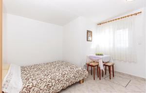 a bedroom with a bed and a table and a window at Beautiful Apartment In Kostrena With House A Panoramic View in Kostrena