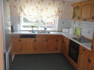 a kitchen with wooden cabinets and a sink and a window at Apartment Schendel in Tettnang