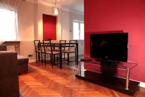 sala de estar con TV y mesa con sillas en Key Apartments Chmielna, en Varsovia