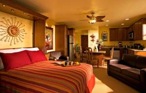 Avila La Fonda Hotel في أفيلا بيتش: غرفة نوم بسرير احمر ومطبخ