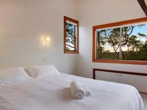 a bedroom with a white bed with a towel on it at Sydney View - Stay 3 Pay 2 in Woodford