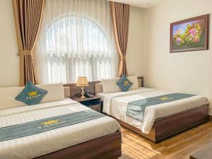 Voodi või voodid majutusasutuse Crown Dalat Hotel toas