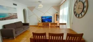 蘇昂博的住宿－Casa MALIBU，客厅配有沙发和墙上的时钟